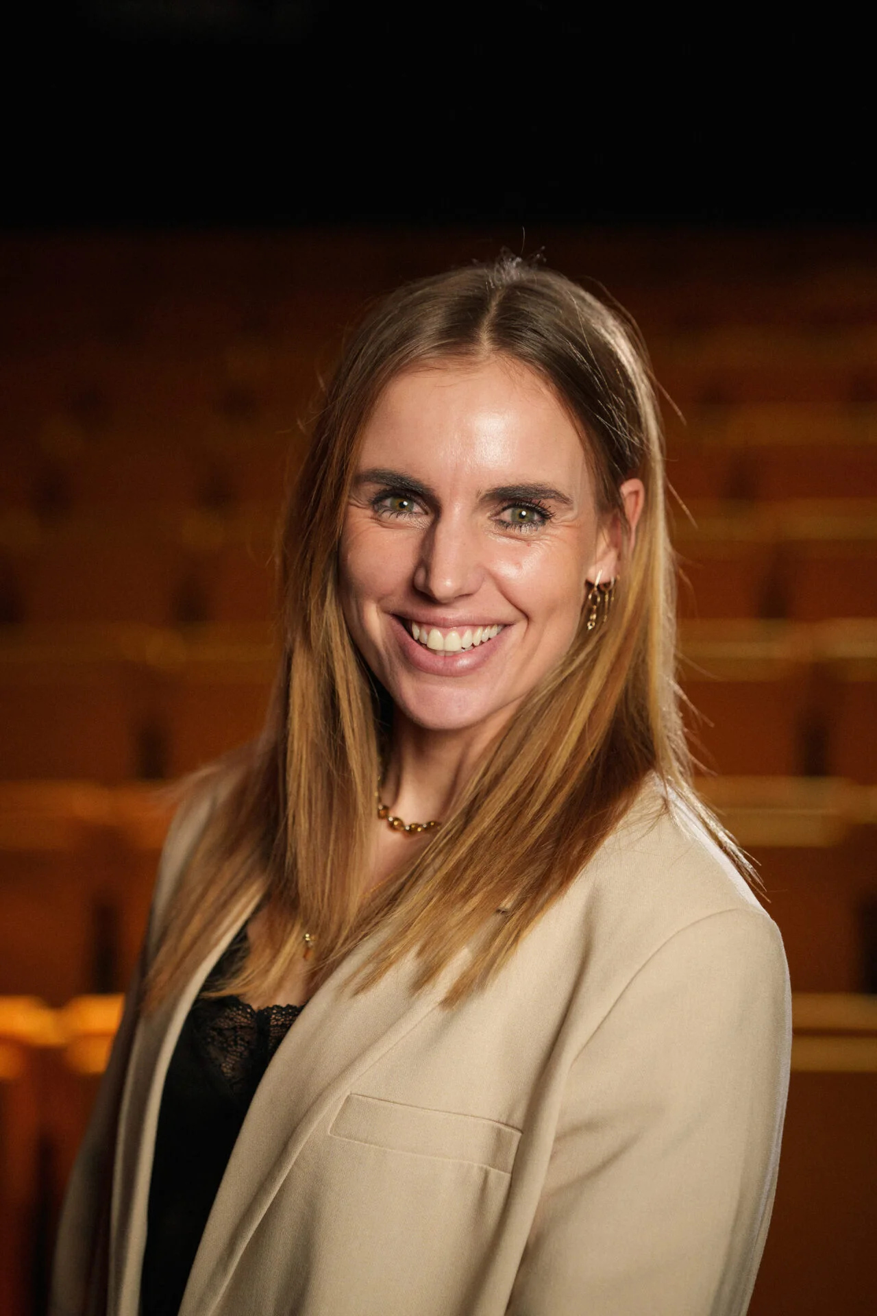 Spreker Marit Bouwmeester lachend in theater.